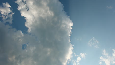 Moving-summer-clouds-time-lapse-against-blue-sky-and-sun-light
