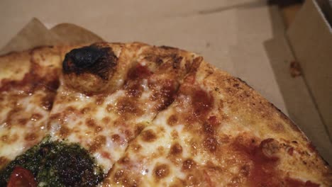 close-up-shot-of-delicious-Italian-pizzas-delivered-in-boxes-on-the-wooden-table-at-home,-zooming-out