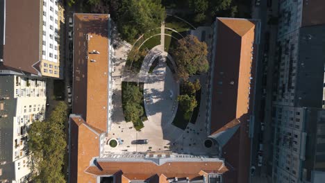 Vista-Aérea-De-Arriba-Hacia-Abajo-De-Los-Edificios-De-La-Ciudad-Y-El-Parque-En-Budapest,-Hungría