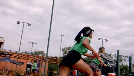 attractive-latina-woman-smashes-padel-ball-and-runs-onto-court-to-win-the-padelgame