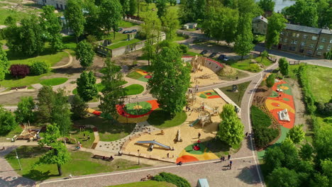 Colorful-park-with-kids-playground,-aerial-drone-orbit-view