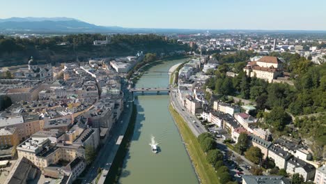 Drone-Flies-Backward-Above-Salzach-River-in-Salzburg,-Austria