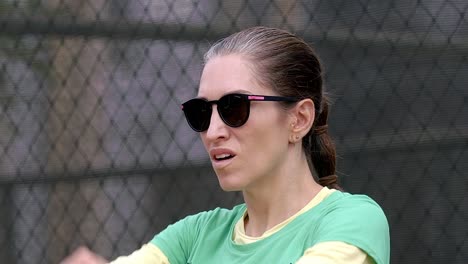 woman-stretching-arms-close-up,-preparation-warming-up-before-padel-match-workout,-wearing-sunglasses