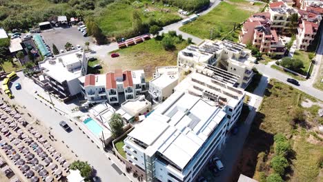 Street-traffic-and-modern-hotel-in-Georgiopoli-town-in-Crete-island,-aerial-view
