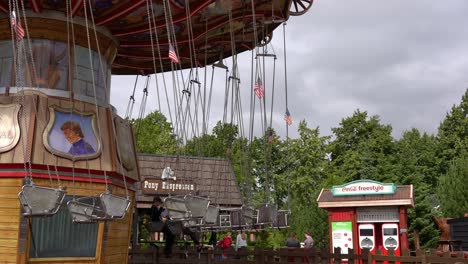 Swing-ride-carousel-starting-to-spin-around-carrying-many-happy-people---Djurs-amusement-park-Denmark