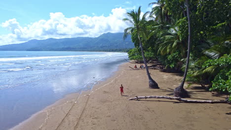 Aerial-view-of-person-walking-over-tropical-beach-in-national-park-of-Manuel-Antonio-in-Costa-Rica