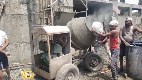Raw-materials-used-for-building-construction-materials-at-the-new-under-construction-site---concrete-mixer-machine,-aggregate-crushed-stone,-and-cement-bag