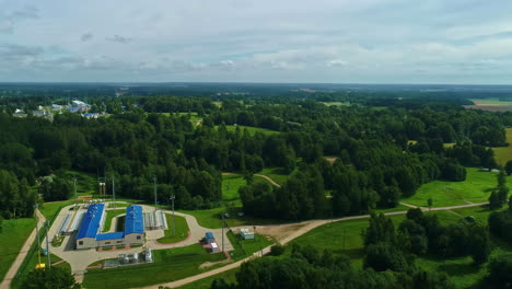 Natural-gas-pumping-station-facility-surrounded-by-forest,-aerial-view