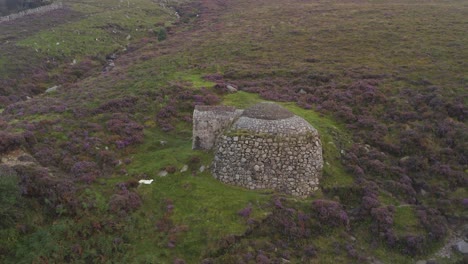 Drone-pulls-back-to-showcase-heathland-of-Slieve-Donard-with-Ice-House-centered