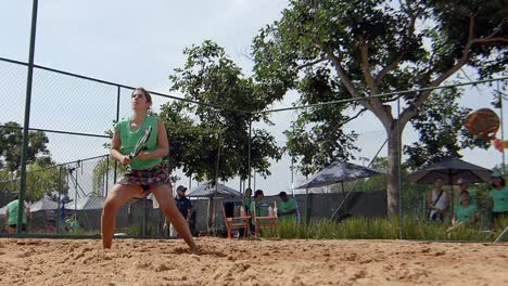 female-team-playing-a-padel-match,-sunny-beach-padel-match-on-sandcourt