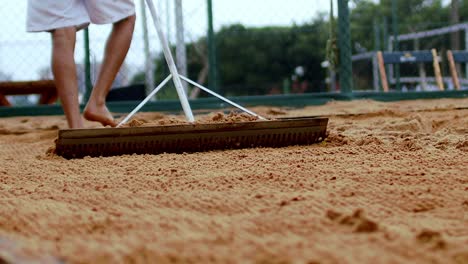 Sand-cleaning-with-rake,-close-up-shot-of-raking-sand-on-a-padel-beach-field