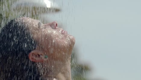 woman-showering-on-the-beach,-head-shot-close-up,-latin-dark-hair,-earring,-hands-through-hair,-washing-hair