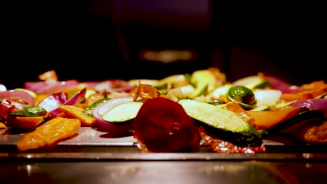A-slow-tracking-shot-of-a-colorful-fried-veggie-mix-on-a-wooden-platter