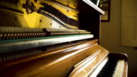 A-slow-shot-of-golden,-warm-light-gleaming-onto-piano-keys