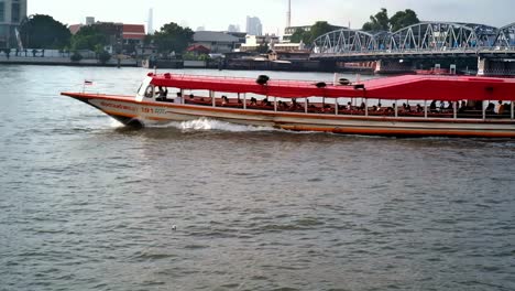 People-aboard-a-river-cruise-boat-enjoy-the-sights-along-the-Chao-Phraya-river,-a-gateway-to-major-tourist-attractions-in-Bangkok,-Thailand