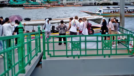 Menschen-Am-Kai-Warten-Auf-Ihr-Boot-Für-Eine-Kreuzfahrt-Auf-Dem-Fluss-Chao-Phraya,-Einem-Tor-Zu-Den-Wichtigsten-Touristenattraktionen-In-Bangkok,-Thailand
