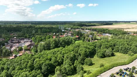 Djurs-Sommarland-amusement-park-in-Jutland-Djursland-Denmark---Descending-aerial-from-full-park-overview-to-parking-lot-outside---60fps