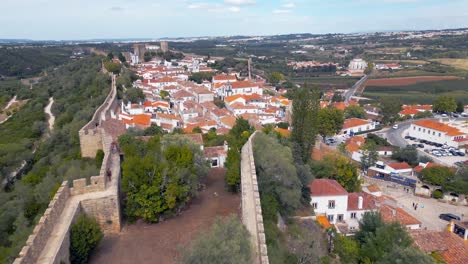Flying-over-Óbidos-Castle,-within-the-walls-with-a-view-of-ancient-rooftops