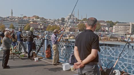 Fishermen-on-the-Galata-bridge-with-Istanbul-skyline-backdrop-slo-mo