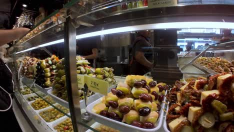 Discover-the-foodie's-paradise-that-is-Mercado-de-San-Miguel-in-Madrid,-where-our-gimbal-shot-allows-you-to-savor-tapas,-cheese,-olives,-and-the-finest-jamón