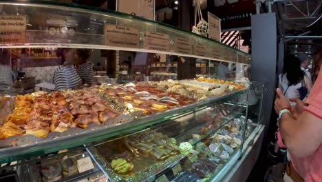 Madrid,-Spain:-Take-a-sensory-journey-through-Mercado-de-San-Miguel,-where-the-aromas-of-freshly-sliced-jamón,-the-vibrant-colors-of-fresh-produce,-and-the-lively-atmosphere-come-to-life-in-our-shot