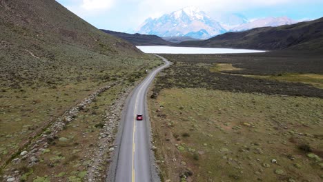 Vuelo-Suave-De-Drones-En-La-Patagonia-Con-Un-Automóvil-En-Un-Largo-Camino-Que-Conduce-A-Las-Montañas