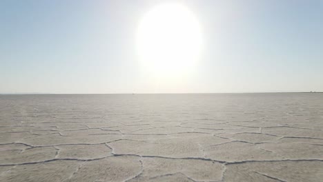 An-intense-low-angle-eternity-drone-shot-above-the-salt-flats-flying-towards-the-sun-and-horizon