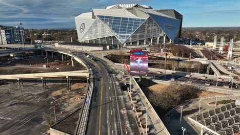 Aerial-flight-over-road-in-Atlanta-in-front-of-Mercedes-Benz-Stadium-and-advertising-billboard