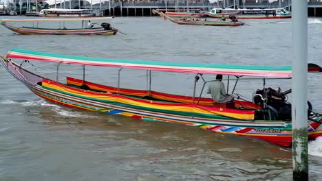 A-water-taxi-on-the-way-to-picking-up-visitors-for-a-trip-on-the-Chao-Phraya-River,-a-favorite-transit-route-for-tourists-visiting-temples-and-other-attractions-in-Bangkok,-Thailand