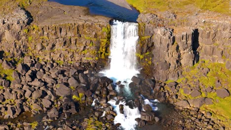 Langsame-Aufnahme-Eines-Wasserfalls,-Der-über-Eine-Klippe-In-Der-Weiten-Isländischen-Landschaft-Fließt