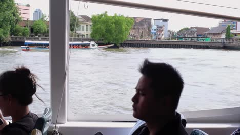 Menschen-An-Bord-Eines-Flusskreuzfahrtschiffs-Genießen-Die-Sehenswürdigkeiten-Entlang-Des-Flusses-Chao-Phraya,-Einem-Tor-Zu-Den-Wichtigsten-Touristenattraktionen-In-Bangkok,-Thailand