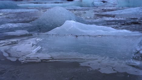 Camera-revealing-frozen-icebergs-of-Jökulsárlón-glacial-lake-in-southern-part-of-Vatnajökull-National-Park,-Iceland