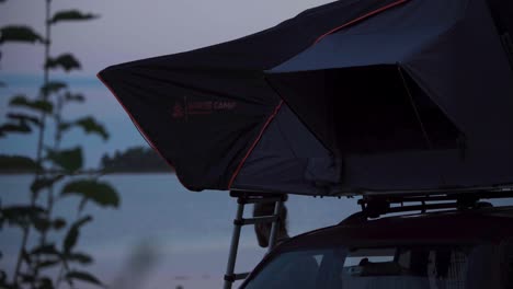 Car-Roof-Tent-With-A-Man-During-Outdoor-Camp-At-Sunset