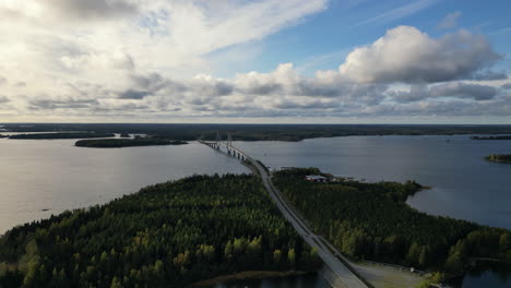 Finland-autumn-landscape-with-forest-and-bridge-over-lake,-aerial-view