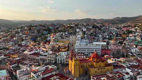 Aerial-view-low-over-the-city-center-of-Guanajuato,-sunny-evening-in-Mexico