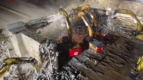 Demolition-Machines-Dismantling-Concrete-Bridge-Structure-At-Night-In-Barrie,-Canada