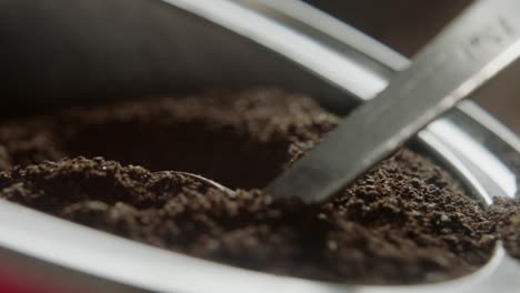 Coffee-grounds-are-scooped-from-a-container