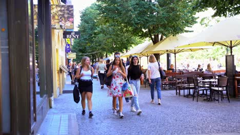 Turistas-Caminando-Y-Comiendo-Algo-En-Un-Caluroso-Día-De-Verano,-Praga,-República-Checa