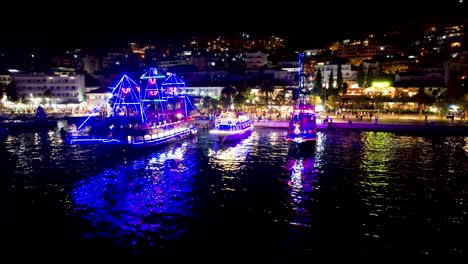 Bunte-Lichter-Auf-Einem-Touristenschiff-Und-Neonbeleuchteter-Pier-Spiegeln-Die-Ruhige-Mittelmeerbucht-Von-Saranda-–-Eine-Perfekte-Sommerurlaubsszene