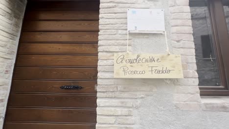 Humorous-writing-on-house-door-for-grape-harvest-festival-of-medieval-Penna-in-Teverina-town-in-Italy