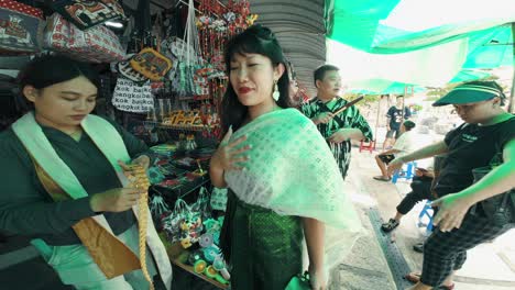 Schöne-Frau,-Die-Auf-Einem-Lokalen-Markt-Mit-Einem-Schal-über-Ihren-Schultern-In-Bangkok-Einkauft