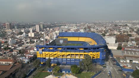 Panoramic-aerial-view-of-Iconic-La-Bombonera-football-stadium-and-neighborhood-under-gray-hazy-sky-due-to-climate-change-and-global-warming,-Buenos-Aires,-Argentina