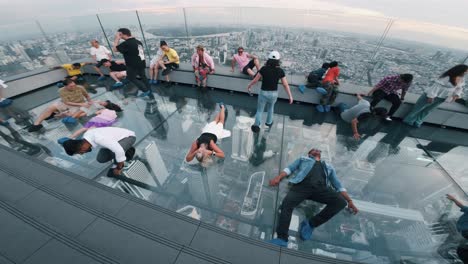 People-suspended-in-a-glass-floored-elevator-in-a-tall-building-in-Bangkok