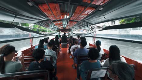 Interior-view-of-a-crowded-water-taxi-with-people-on-board,-and-a-woman-busy-texting-on-her-mobile-phone