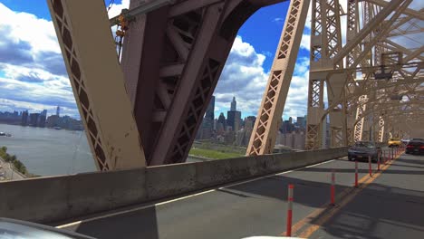 Pov-shot-of-cars-crossing-East-River-on-Queensboro-Bridge-during-sunny-day-in-NYC