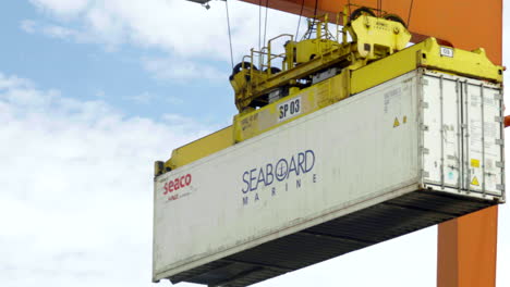 panning-shot-of-a-container-gantry-crane-on-a-rail-loading-the-container-onto-a-barge