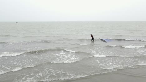 Fisherman-Walking-In-The-Sea,-Pulling-Fishing-Net-In-Kuakata,-Bangladesh