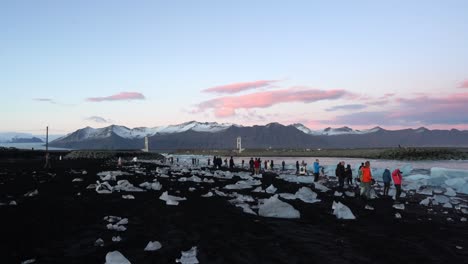 Multitud-De-Turistas-En-Diamond-Beach,-Playa-De-Arena-Negra-Con-Icebergs-En-La-Orilla,-Islandia