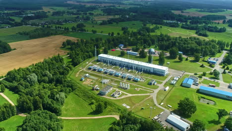 Aerial-view-tilting-away-from-a-Natural-gas-compressor-station,-sunny,-summer-day