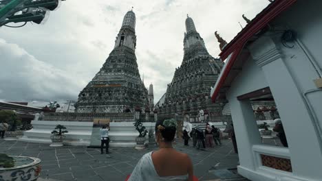 A-woman-entering-a-site-with-two-historic-and-famous-pyramids-in-Wat-Arun-of-Bangkok